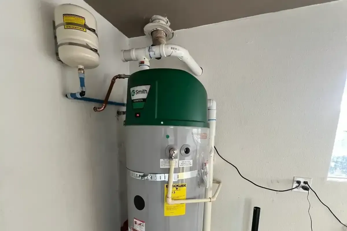 A water heater with an expansion tank, installed in a utility space, highlighting seasonal maintenance importance.